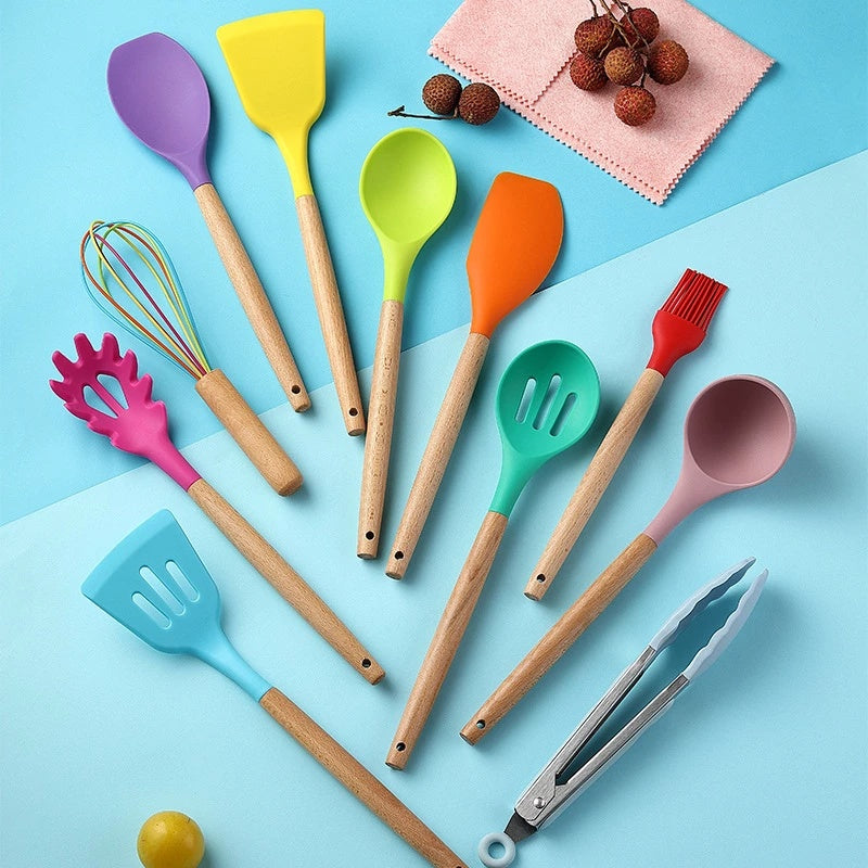 Colorful silicone kitchen utensils set with wooden handles on a blue background, featuring spatulas, whisks, and tongs.