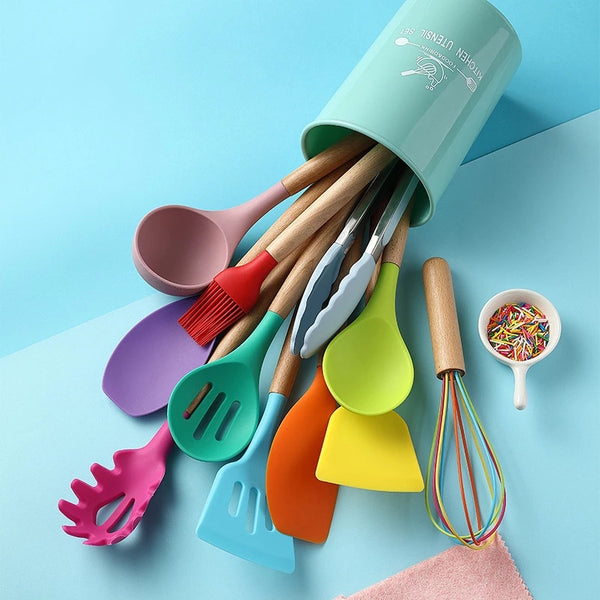 Colorful silicone kitchenware utensils set in a green container, featuring spatulas, ladles, and whisk, perfect for non-stick cooking.