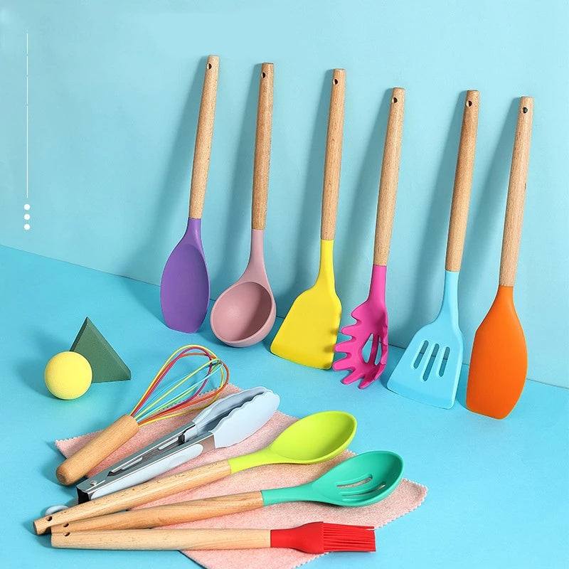Colorful silicone kitchen utensils set with wooden handles on blue background, ideal for non-stick cooking and baking.