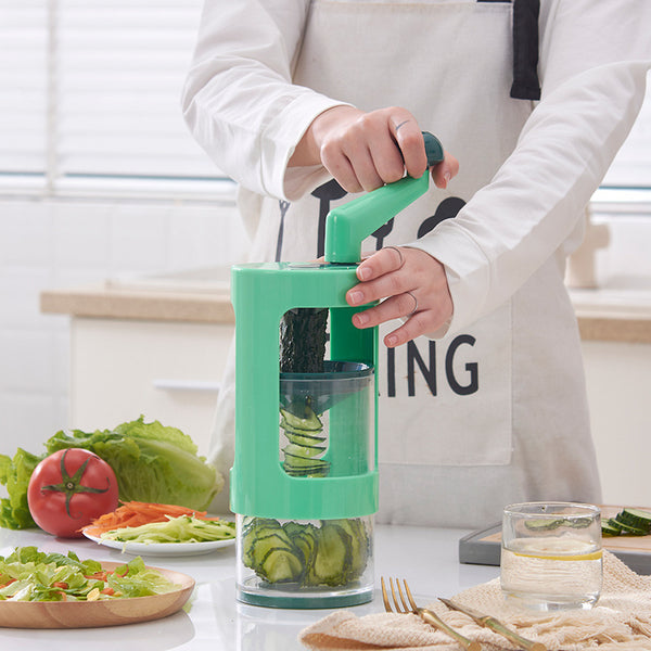 User operating a multifunctional vegetable cutter in a kitchen with fresh ingredients around.