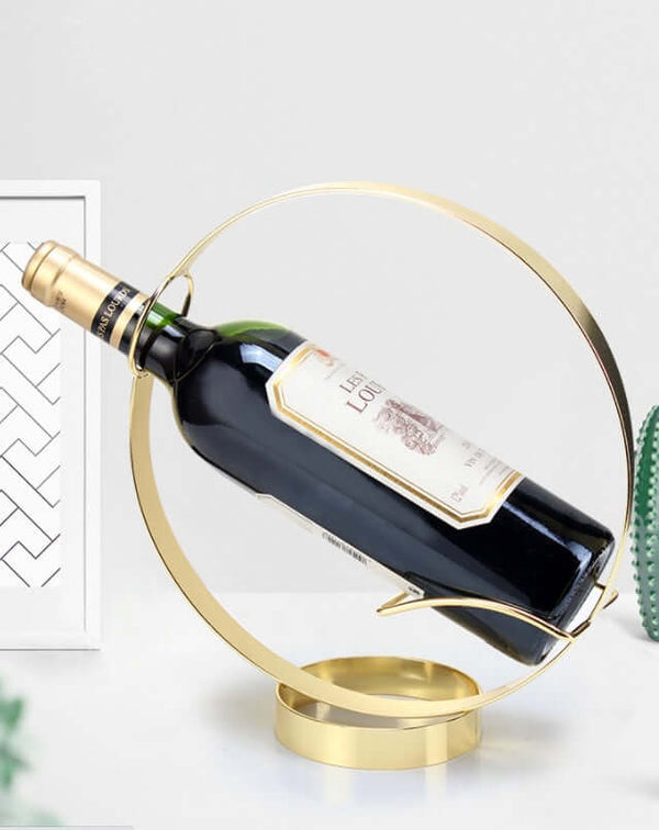 Modern gold circle wine rack displaying a wine bottle, perfect for minimalist decor and creative interior styling.