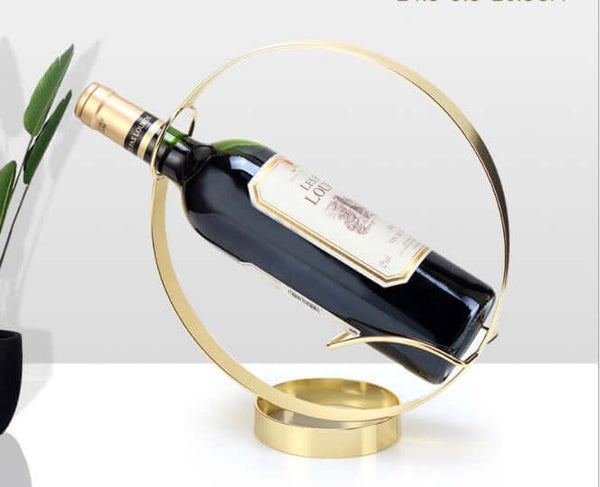 Modern minimalist golden circle wine rack displaying a bottle of red wine, perfect for stylish home decor.