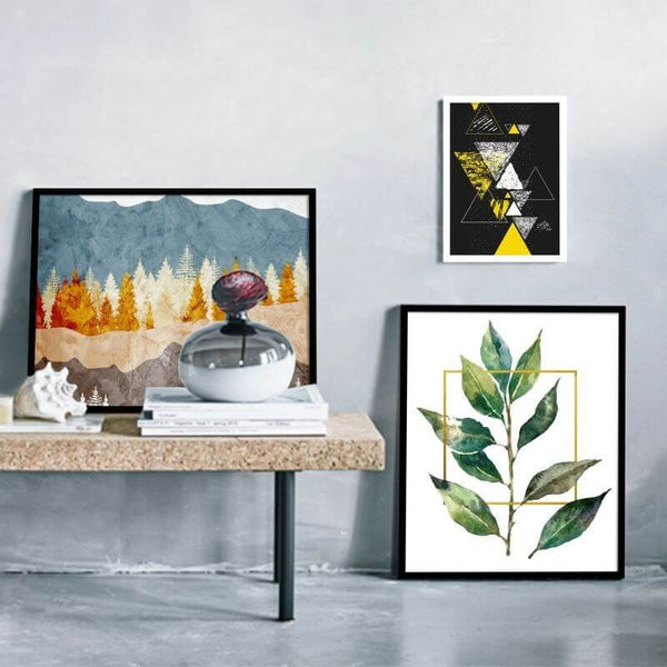 Stylish solid wood picture frames displaying abstract and botanical art on a modern coffee table.
