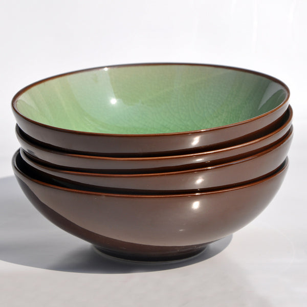 Set of four round porcelain bowls with green interior and brown exterior, perfect for kitchen use.