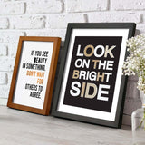 Two solid wood picture frames with inspirational quotes displayed on a rustic wooden surface.