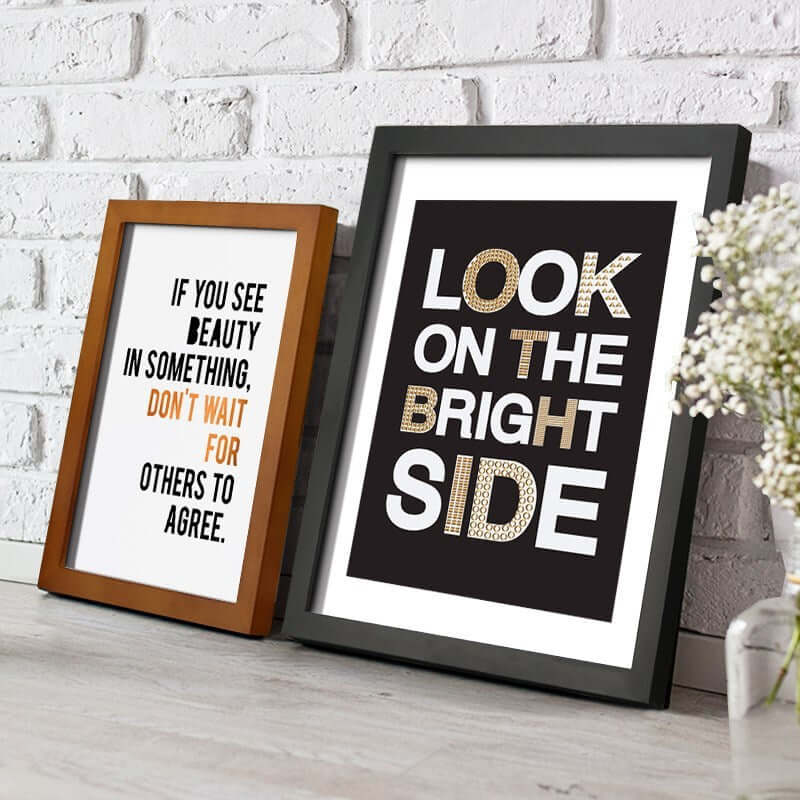 Two solid wood picture frames with inspirational quotes displayed on a rustic wooden surface.
